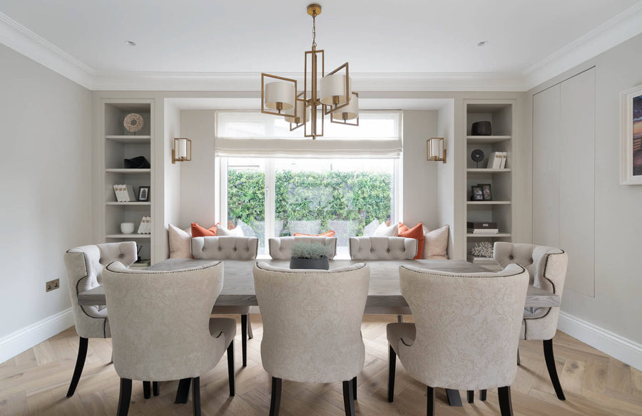 Dining room with a brass chandelier, a cushioned window seat and alcove shelving