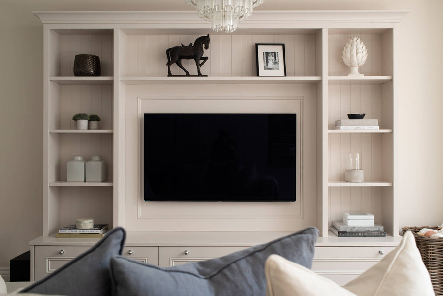Bespoke media wall with open shelving, a bronze horse sculpture and a wall-mounted television