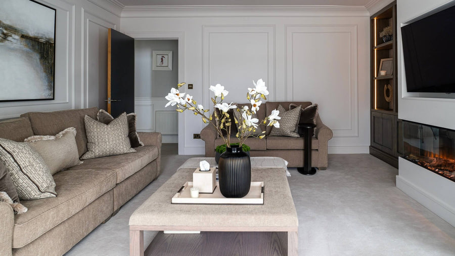 Neutral living room with bespoke dark timber joinery, an inset fire and a deep linen sofa