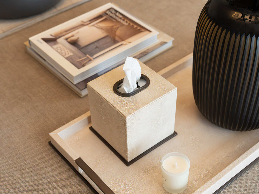 Linen-covered tray styled with a stone box, a candle and an interiors book